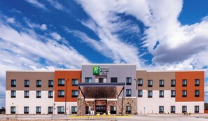 Un hotel Holiday Inn Express con fachada moderna, varios pisos y cielo despejado.