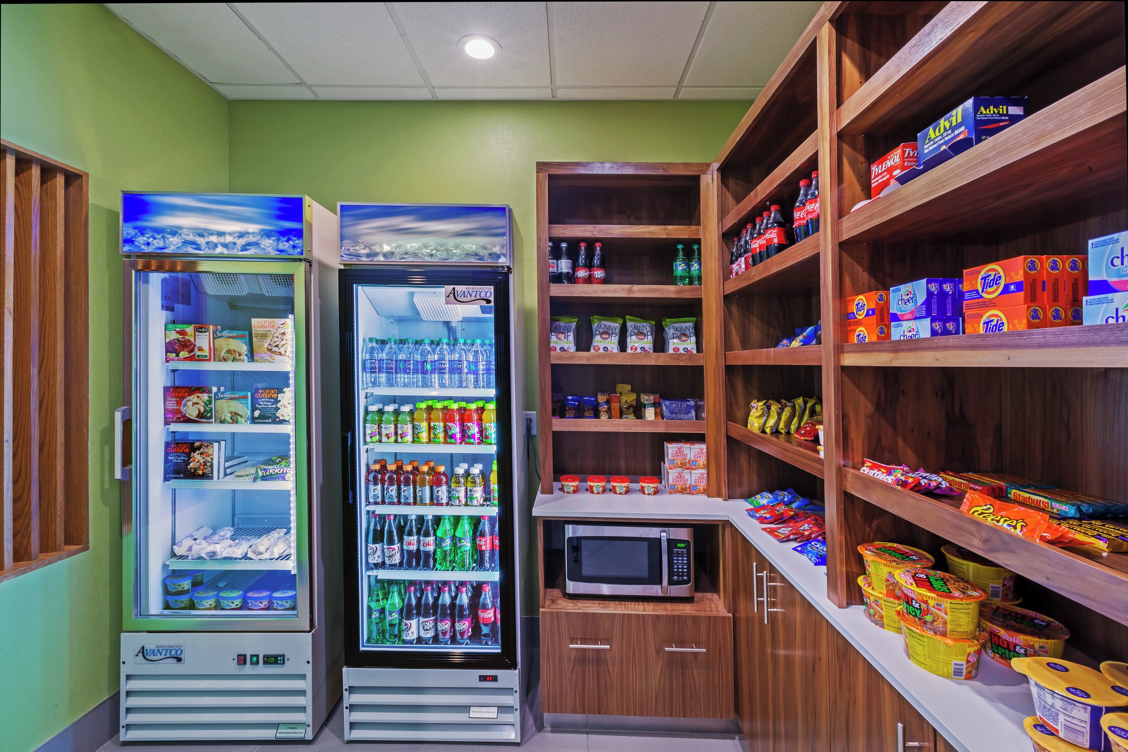 A vending machine area with various snacks and drinks, including a microwave and a refrigerator.