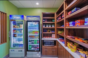 A vending machine area with various snacks and drinks, including a microwave and a refrigerator. - Holiday Inn Express & Suites Perryton by IHG (Perryton)