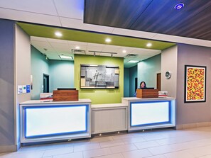 A reception area with two reception desks, a clock, and a framed abstract art piece on the wall. - Holiday Inn Express & Suites Perryton by IHG (Perryton)
