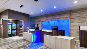 A reception area with a vending machine, a digital screen, and a blue-lit wall. - Fairfield Inn & Suites by Marriott Chicago Schaumburg (Schaumburg)