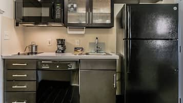 Una cocina equipada con lavavajillas, cafetera y refrigerador.