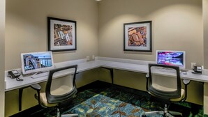 A conference room with two desks, each with a computer monitor, a telephone, and a keyboard. The room has a carpeted floor and two framed artworks on the walls. - Candlewood Suites Hartford Downtown by IHG (Hartford)