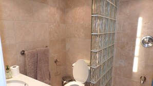A bathroom with a toilet, sink, and shower area. - Villa 230C at Jolly Harbour (Jolly Harbour)