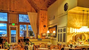 A cozy restaurant with wooden furniture, a dining area, and a kitchen visible through the windows. - Haven By The Sea B&B Inn (Wells)
