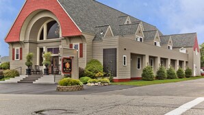 A two-story building with a red roof, a large arched entrance, and a sign that reads "Haven By The Sea B&B". - Haven By The Sea B&B Inn (Wells)