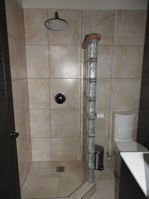 A bathroom with a shower, toilet, and sink.