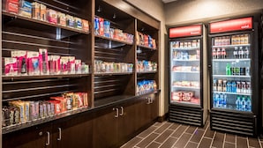 A snack and beverage display area with shelves stocked with various snacks and a refrigerated section with bottled drinks.