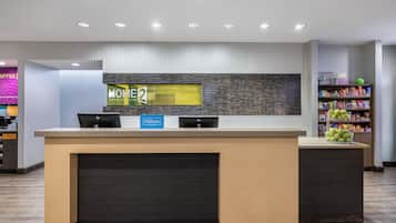 A hotel reception desk with a modern design, a digital display, and a sign indicating 'Hilton Honors'.