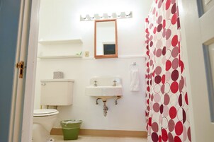 Un baño con inodoro, lavamanos y cortina de ducha.