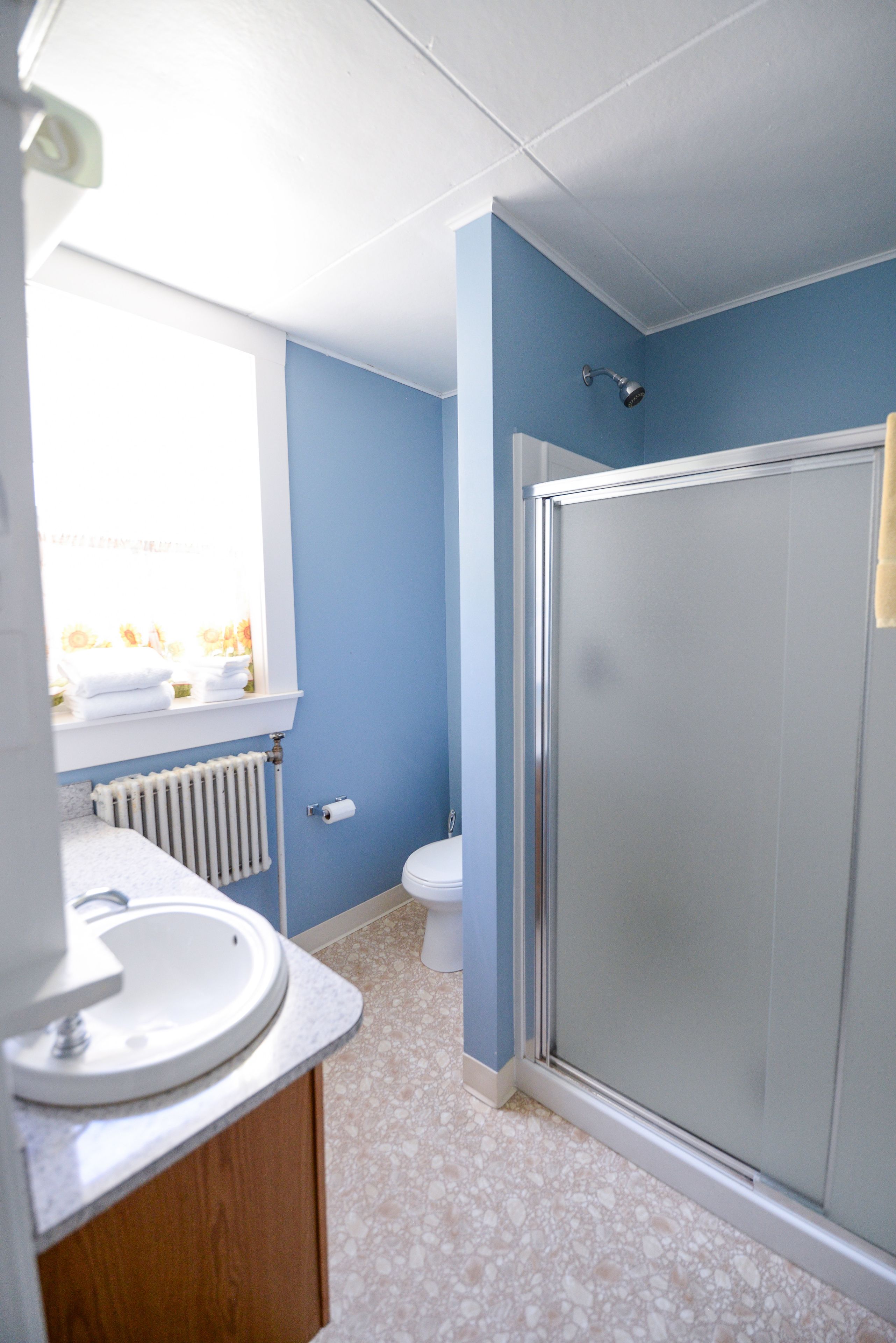 A bathroom with a white sink, a toilet, and a glass shower enclosure.