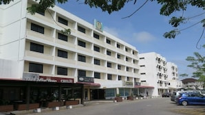 A multi-story building with a central atrium, several ground-level shops, and a parking area. - Seaview Hotel (Bandar Seri Begawan)