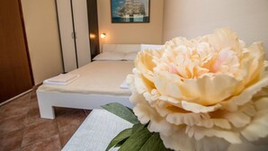 A bedroom with a bed, a nightstand, and a large flower. - Apartment Divna (Rovinj)