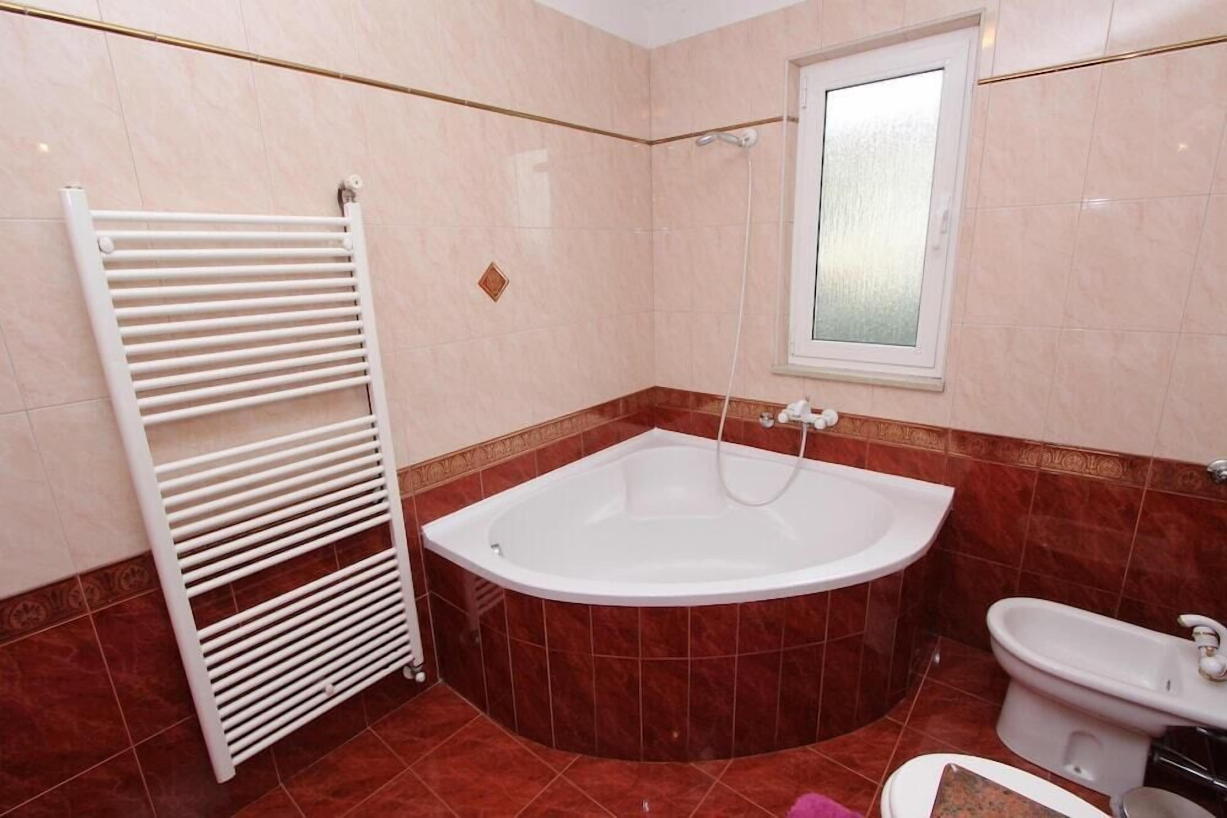 Une salle de bain avec une baignoire, des toilettes et une douche.