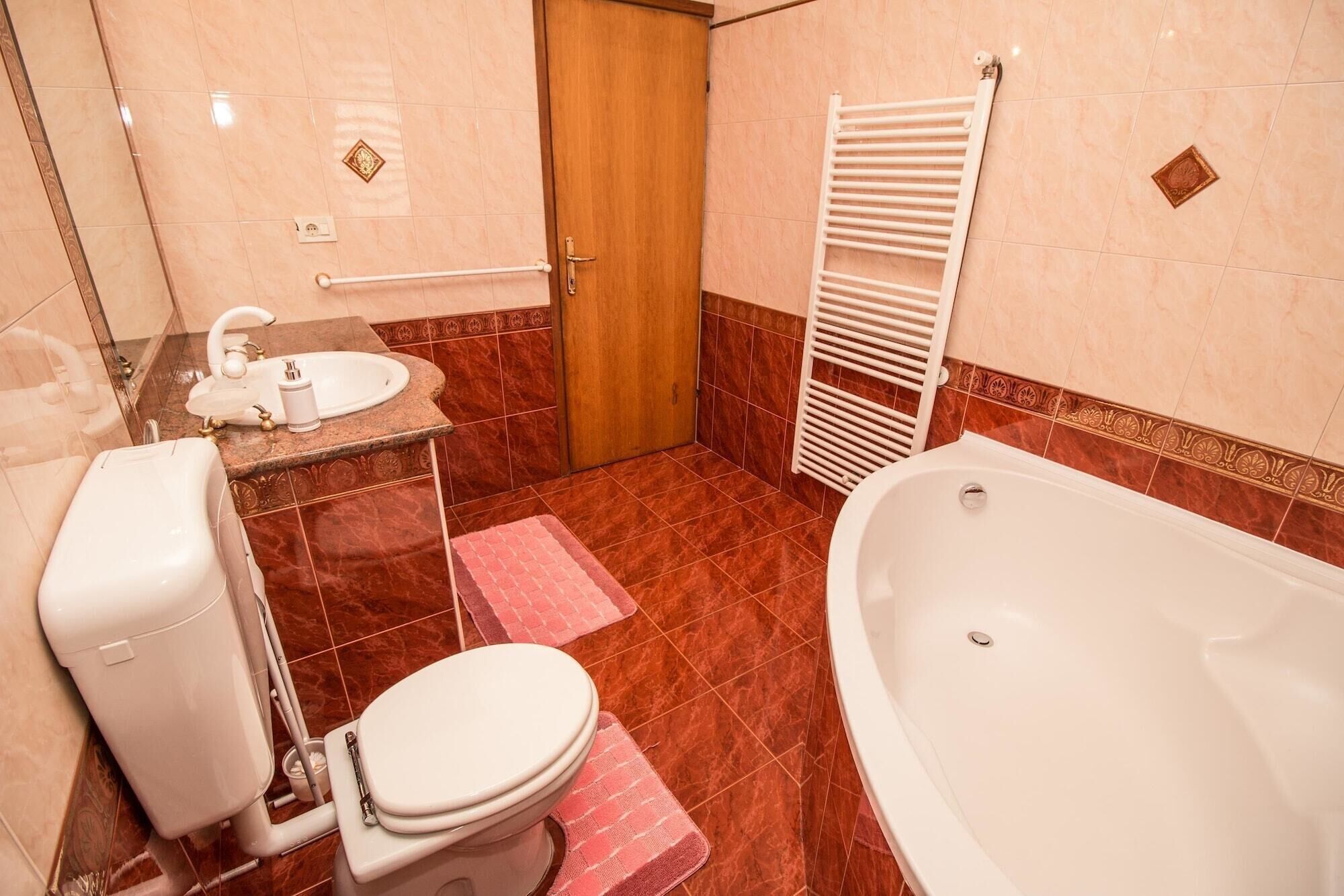 Une salle de bain comprenant des toilettes, un lavabo, une baignoire et un espace douche.