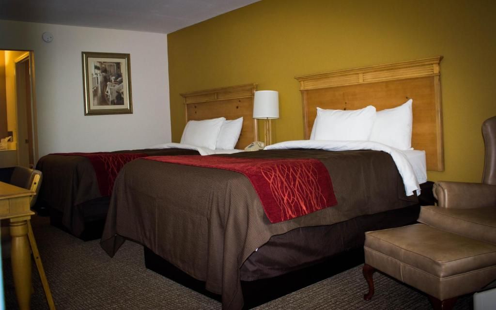Una habitación de hotel con dos camas, un escritorio y una silla.