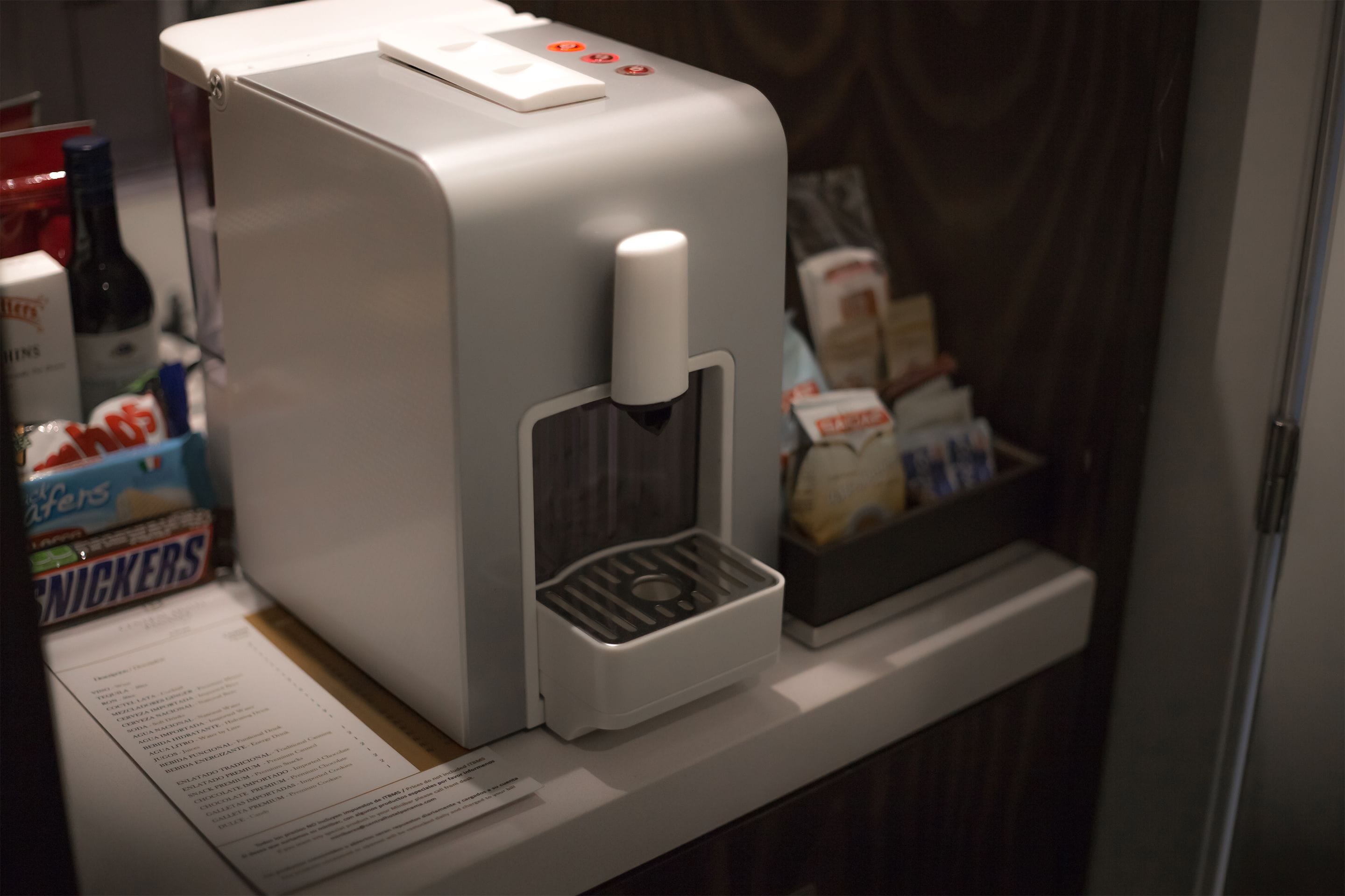 A coffee machine with a paper menu on a counter.
