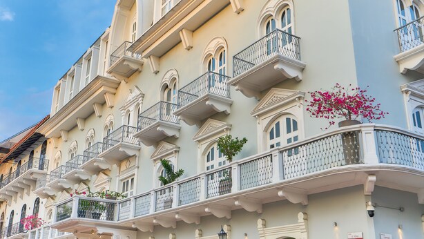 A multi-story building with balconies, arched windows, and decorative railings.