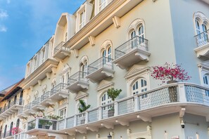 Un edificio de varios pisos con balcones, ventanas en arco y barandillas decorativas.
