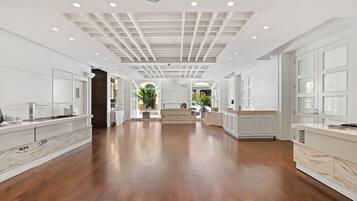A spacious kitchen with wooden flooring, white cabinetry, and a central island.