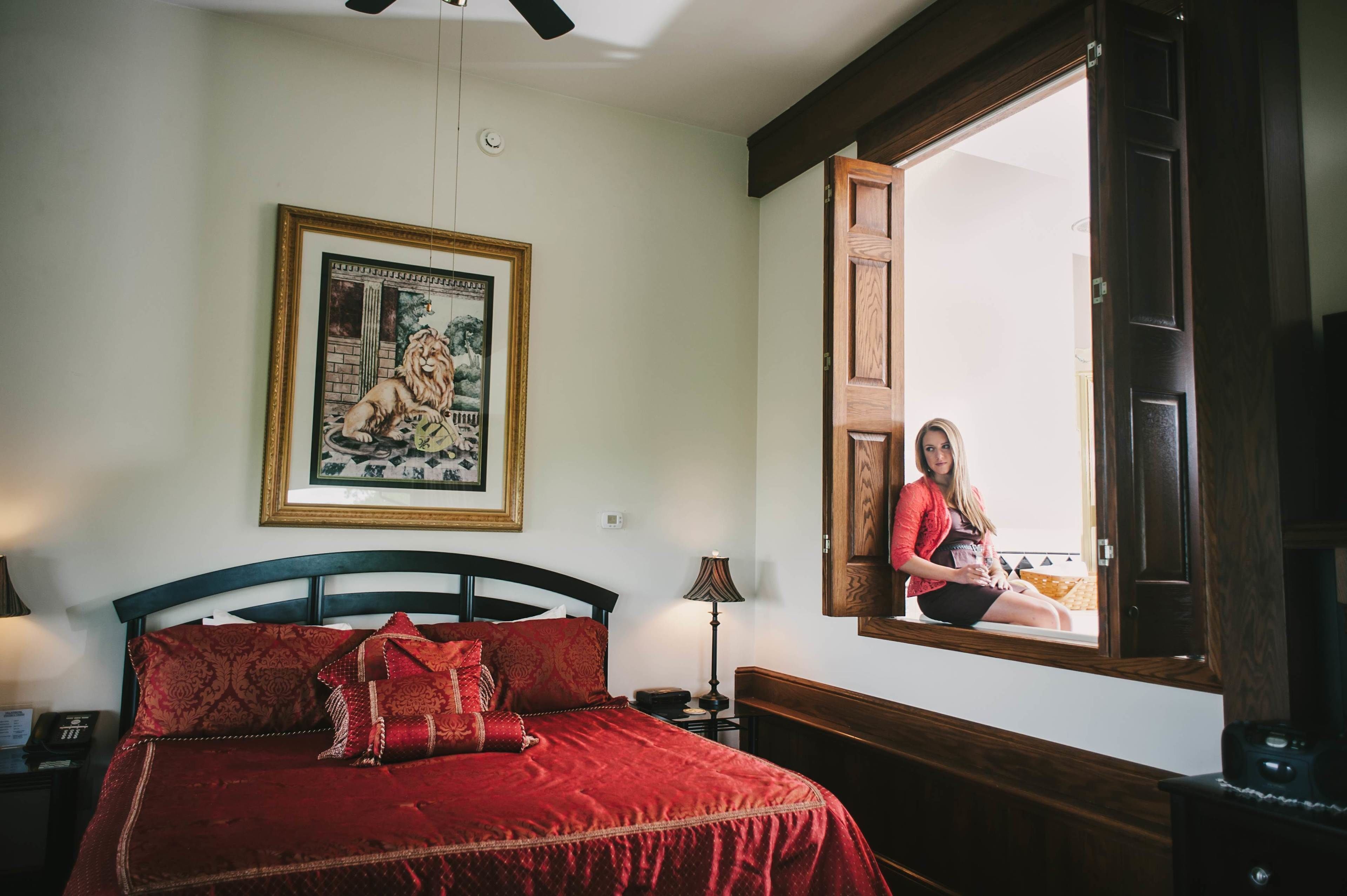Camera da letto con un letto grande, un quadro appeso al muro, un comodino, una lampada e una finestra con vista.