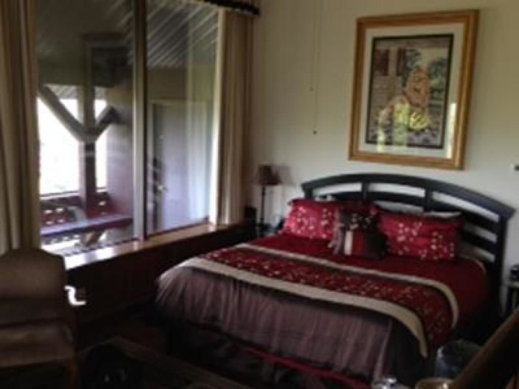 Ein Schlafzimmer mit Bett, Fenster und einem Bild an der Wand.