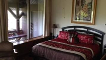 Un dormitorio con cama, ventana y un cuadro en la pared.