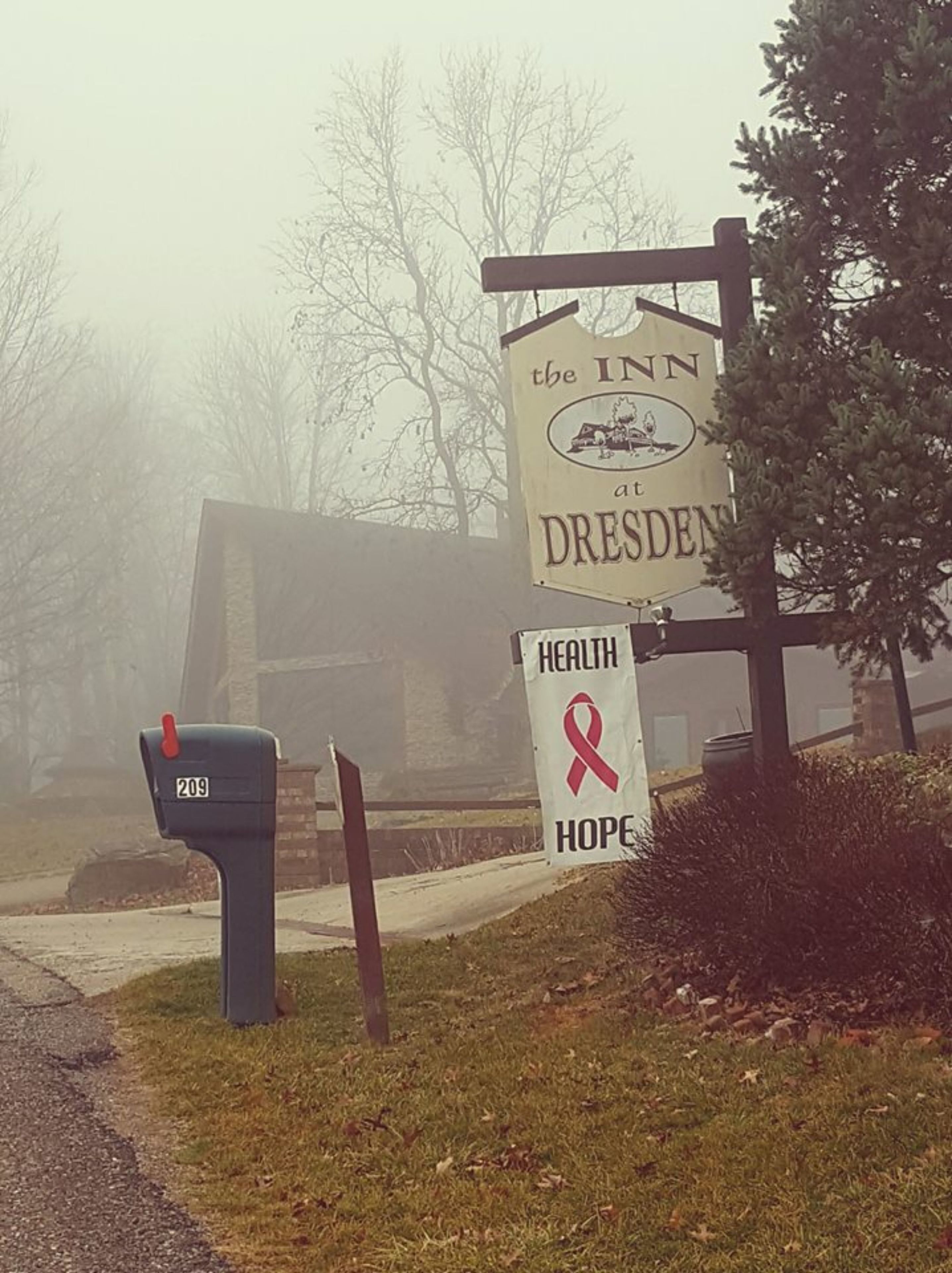 Letrero que dice 'The Inn at Dresden' con un banner de salud y esperanza.