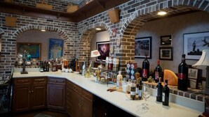 A bar area with brick arches, a counter with various bottles, and framed pictures on the walls. - The Inn at Dresden (Dresden)