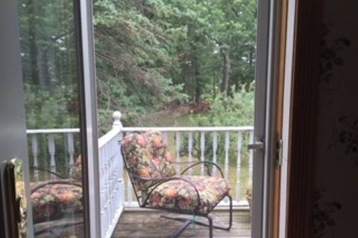 A balcony with a wooden floor and a white railing.