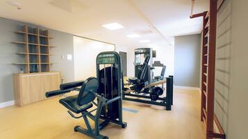 A gym with exercise machines, a wooden cabinet, and a pull-up bar.