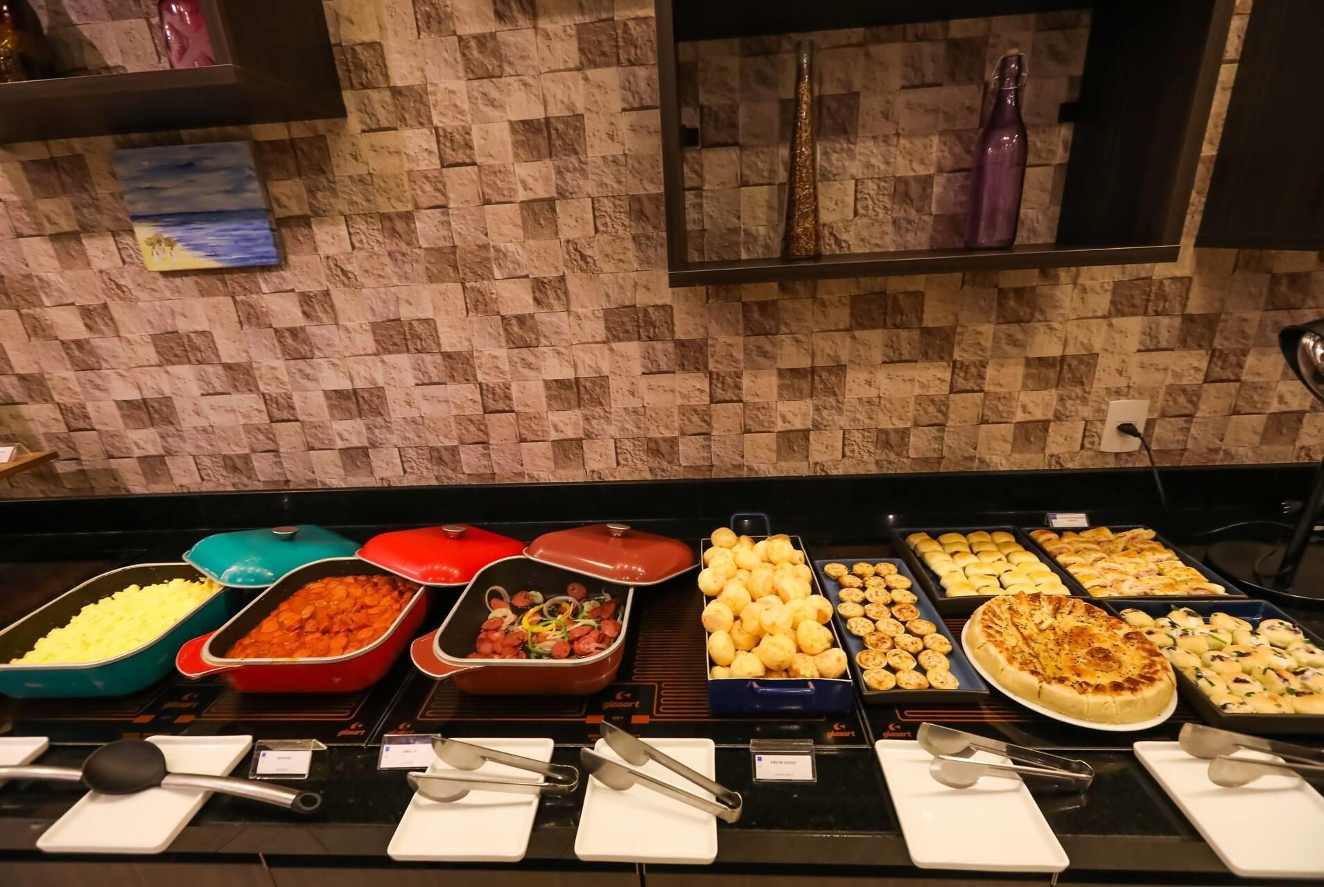 Un buffet con diversi cibi e utensili per servire.