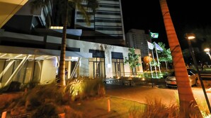 A modern building with a glass facade and palm trees in the foreground. - TRYP by Wyndham Ribeirão Preto Nacional Inn (Ribeirão Preto)