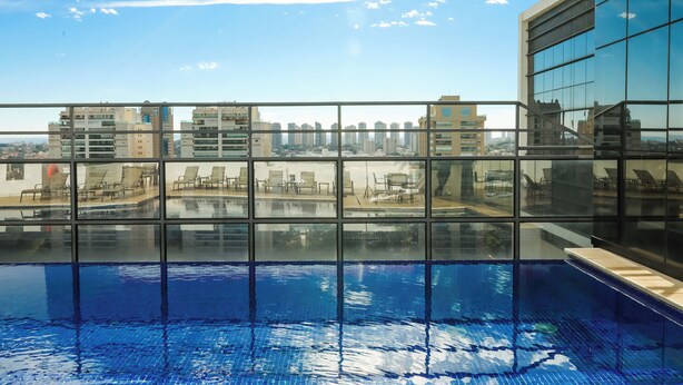 A rooftop pool with a cityscape view, large windows, and a modern building facade. - TRYP by Wyndham Ribeirão Preto Nacional Inn (Ribeirão Preto)