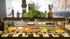 A buffet with various food options and a seating area in the background. - TRYP by Wyndham Ribeirão Preto Nacional Inn (Ribeirão Preto)