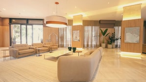 A spacious lobby with a large sofa, multiple armchairs, a coffee table, and a reception desk. - TRYP by Wyndham Ribeirão Preto Nacional Inn (Ribeirão Preto)