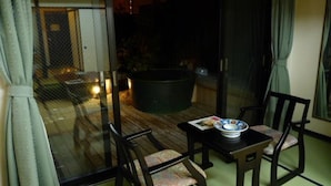 Une pièce dotée d’une porte-fenêtre coulissante donnant sur un balcon, d’une petite table avec un saladier, et de deux chaises.