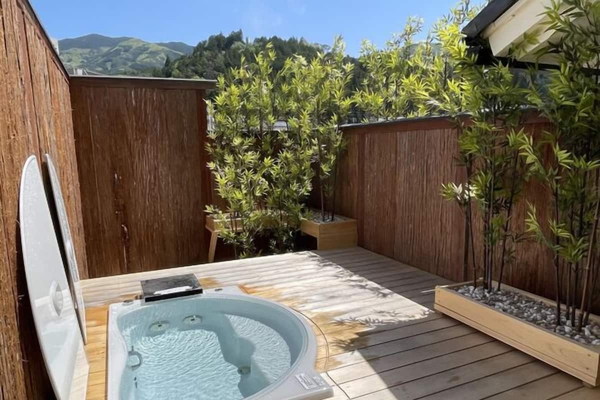 Un bain à remous sur une terrasse en bois, avec vue sur les collines.