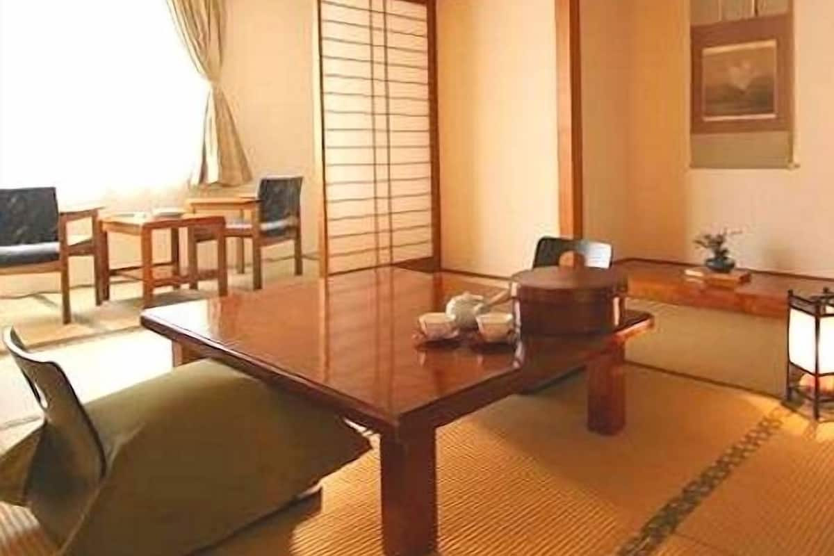Une pièce de style japonais traditionnel, avec un sol recouvert de tatamis, une table basse et des portes coulissantes.