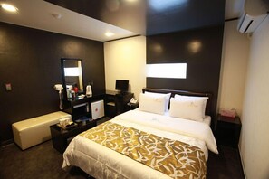 A hotel room with a bed, bedside table, desk, and a bench. - La Nuit Hotel (Jeonju)