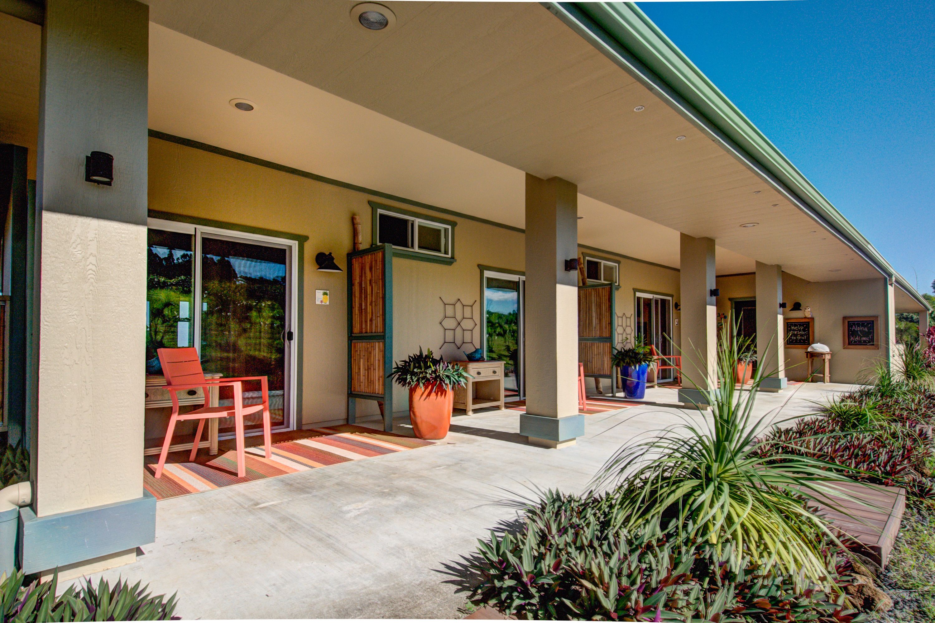 A covered outdoor area with a patio, seating, and potted plants.