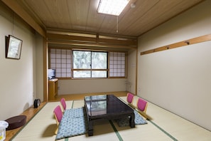 A traditional Japanese room with tatami flooring, a low wooden table, and a shoji screen window. - Inuyama International Youth Hostel (Inuyama)