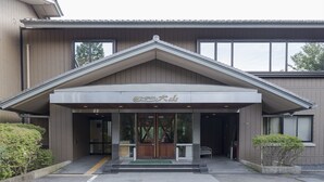 A building with a tiled facade, a large entrance with glass doors, and a sign above the entrance. - Inuyama International Youth Hostel (Inuyama)