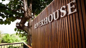 Un mur en bois sur lequel on peut lire en grandes lettres le mot « RIVERHOUSE ».