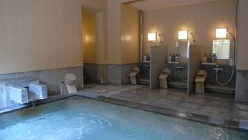A public restroom with multiple sinks, mirrors, and a pool area.