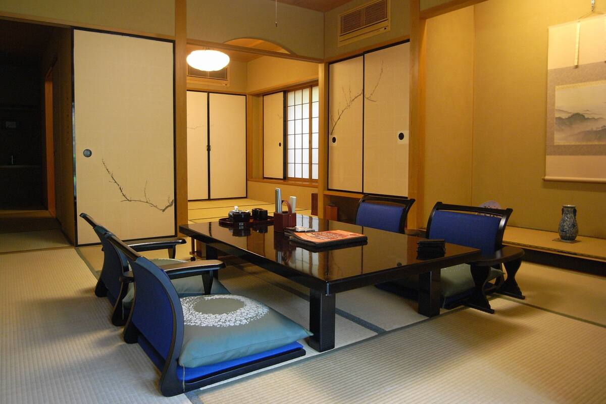 Ein traditioneller japanischer Besprechungsraum mit Tatami-Boden, niedrigen Tischen und Shoji-Schirmwänden.