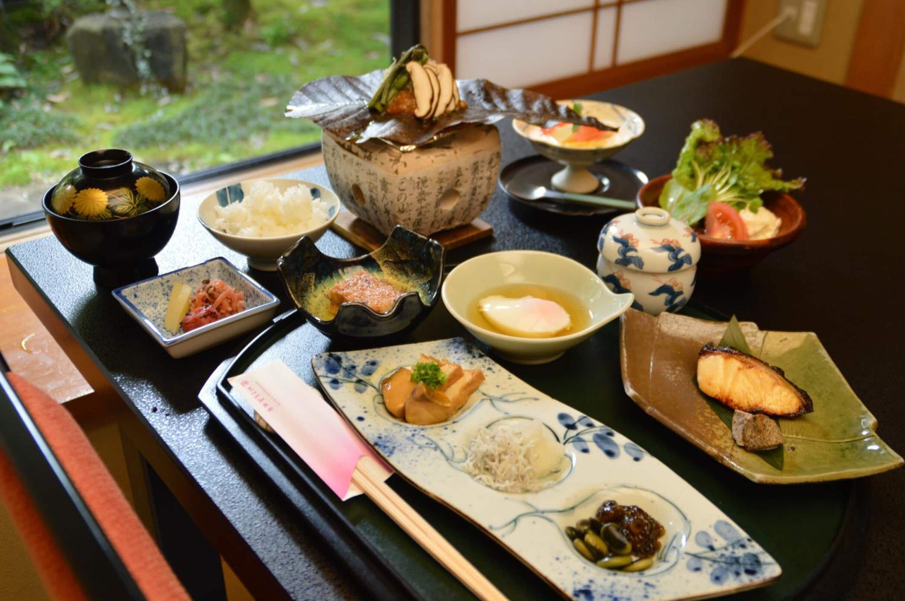 A traditional Japanese meal with various dishes including fish, rice, and vegetables.