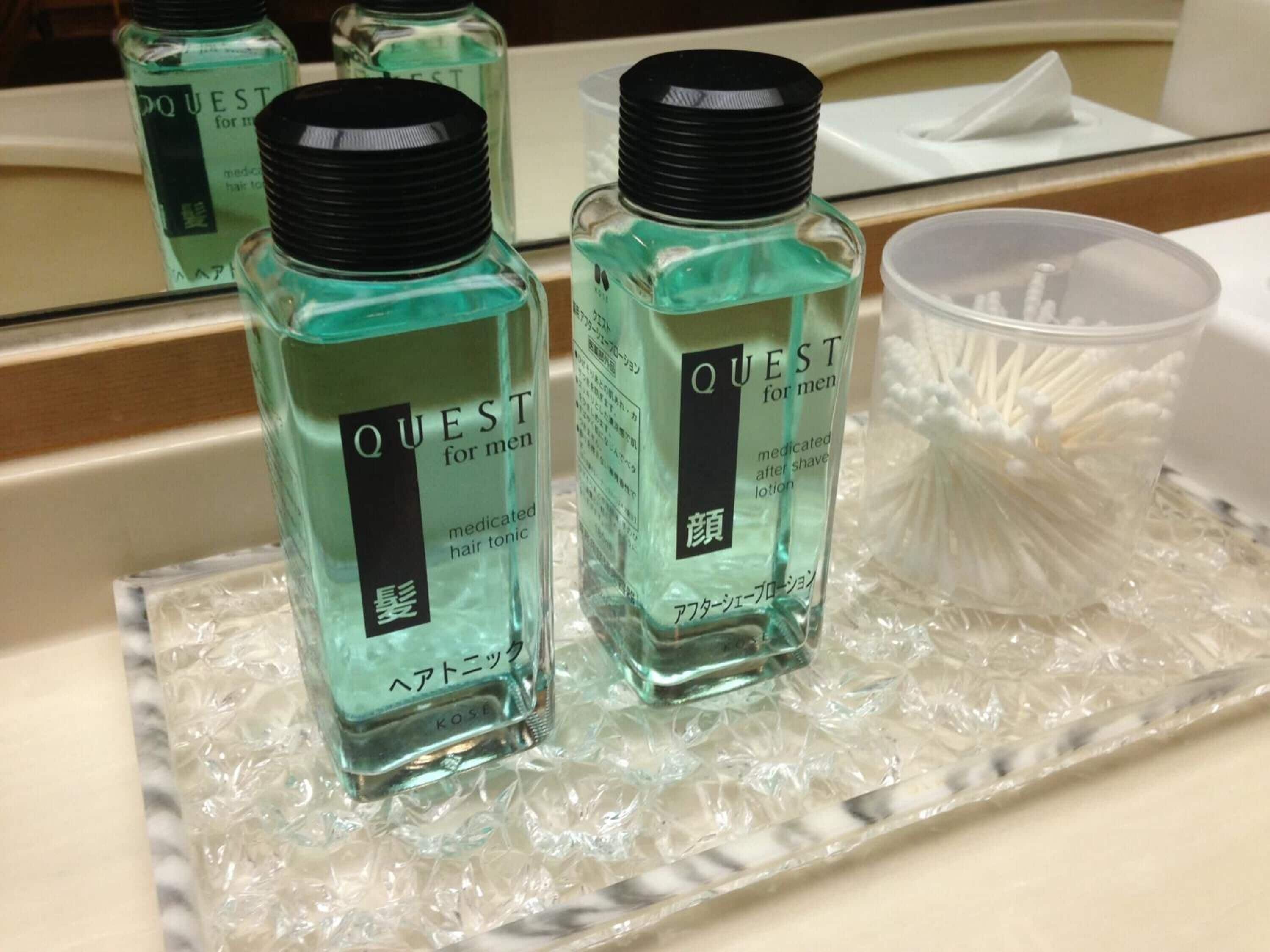 Two bottles of Quest for men medicated hair tonic and lotion on a tray.