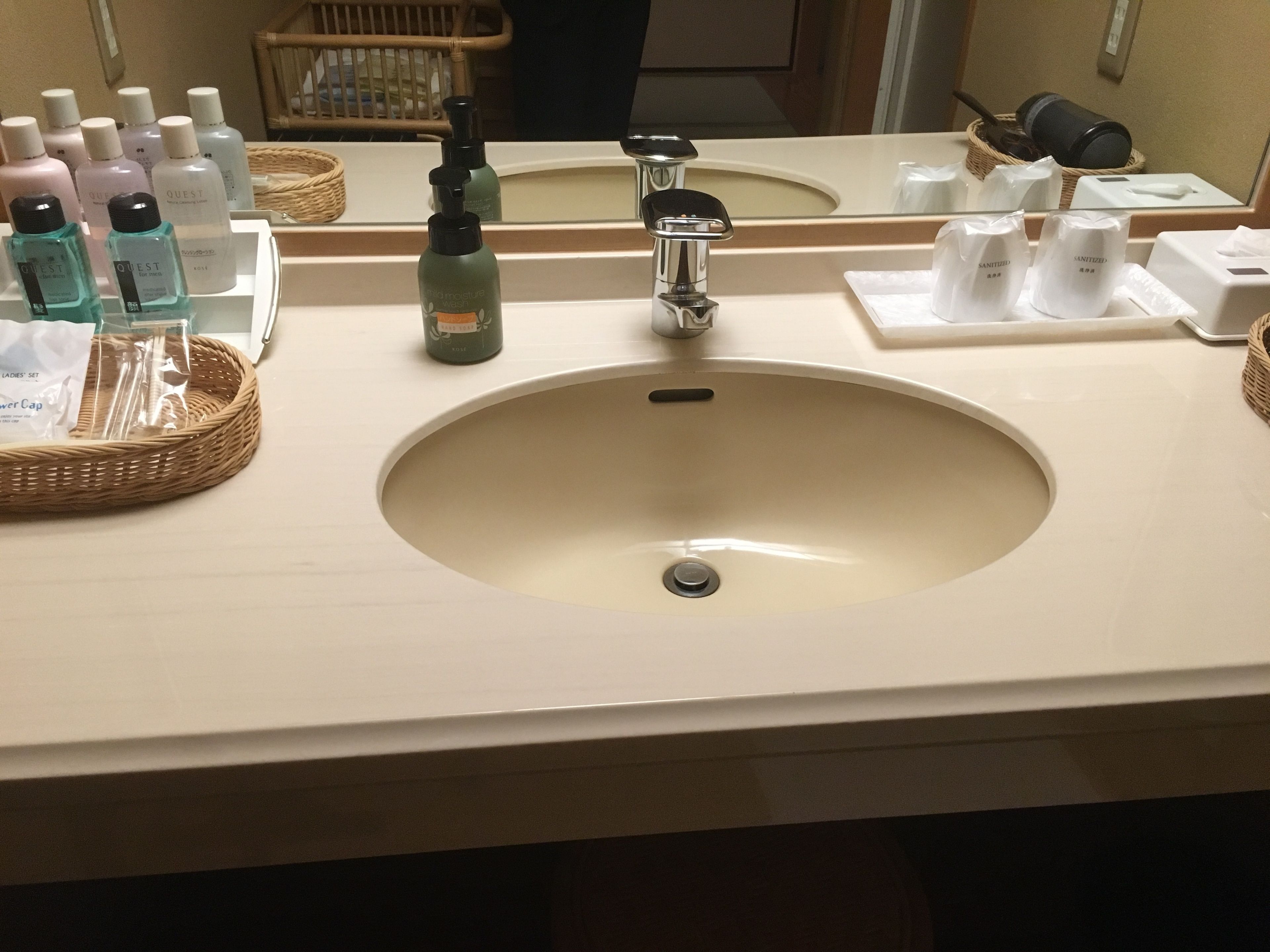 A bathroom sink with toiletries and a mirror.