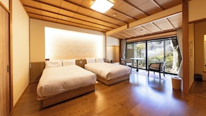 Habitación de hotel con dos camas, un ventanal grande y vistas al exterior.